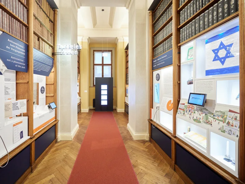 Blick in den Bibliotheksgang mit Ausstellungsobjekten